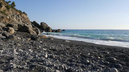 a rocky beach with the ocean in the background at Vinomare Guesthouse in Fosdinovo
