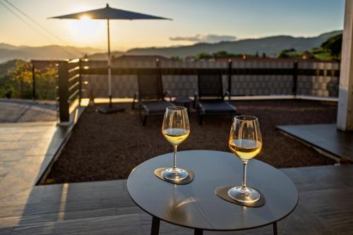 two glasses of wine sitting on a table on a balcony at Vinomare Guesthouse in Fosdinovo