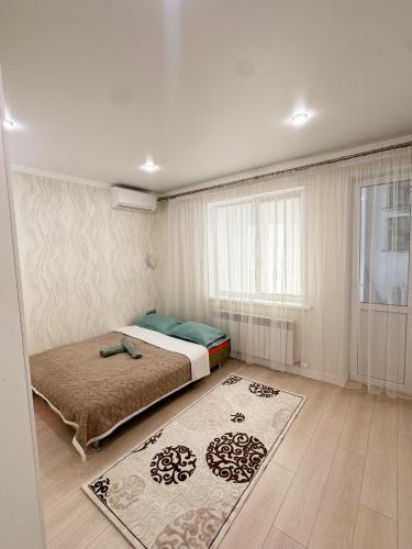 a bedroom with a bed and a window and a rug at Light House apartments in Astana