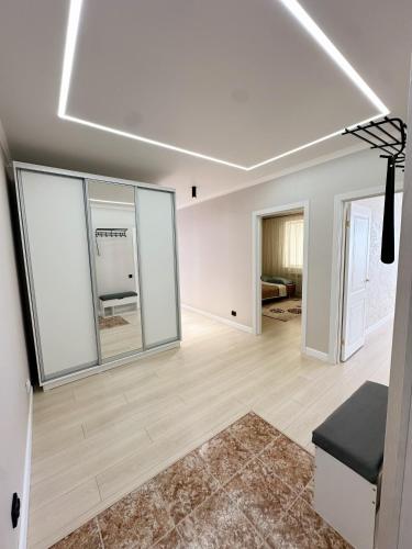 a living room with white walls and large windows at Light House apartments in Astana