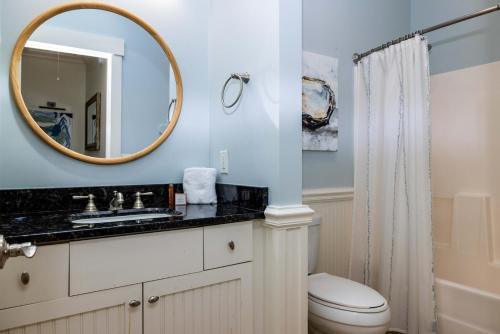 a bathroom with a toilet and a mirror at 111 Cardinal Crest - Resort Access & Golf Cart Included! in Fripp Island
