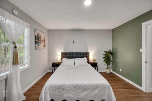 a bedroom with a white bed and two windows at 4 Bed Moroccan style, min to UNC, Kids Essentials, Crib, walk to Golf in Chapel Hill