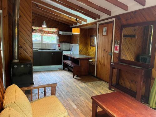 a living room with a stove and a kitchen at Cabañas y Domos Calafquen in Coñaripe