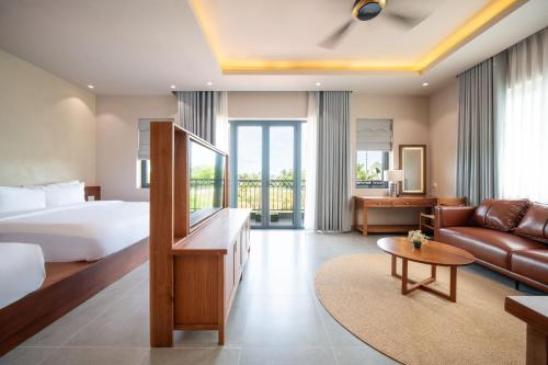 a hotel room with a bed and a couch at JULIE's HOUSE - A LUXURY APARTMENT IN HUE in Hue