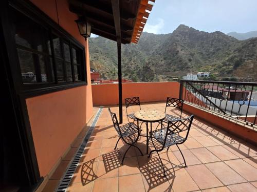 a patio with a table and chairs on a balcony at Tamahuche Hotel Rural in Vallehermoso