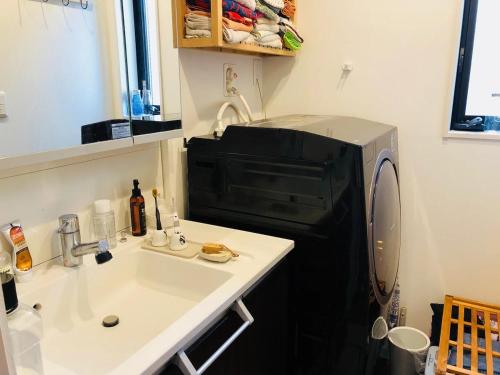 東京にあるCasa Descanso Private Room Toilet and Showerのシンクと電子レンジ付きのキッチン