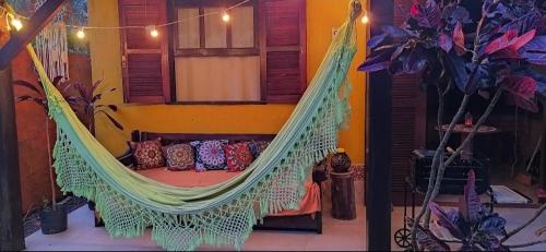 a hammock with pillows in a room at Recanto Zen Praia do Rosa in Praia do Rosa