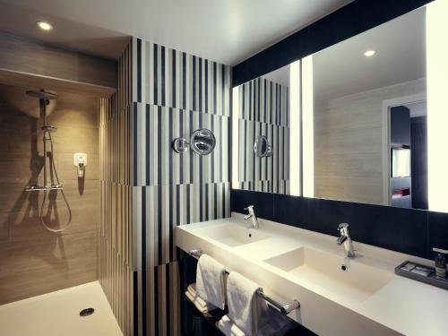 a bathroom with two sinks and a large mirror at Mercure Orange Centre A7/A9 in Orange