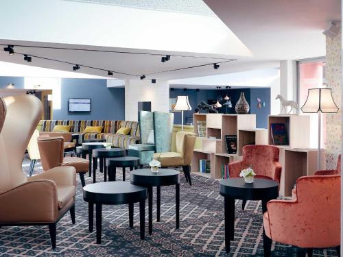 a waiting room with chairs and tables and chairs at Mercure Orange Centre A7/A9 in Orange