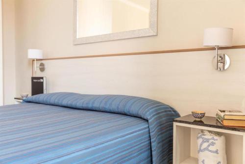 a bedroom with a bed with a blue comforter at Happy Sea Home - monolocale sul mare in Albinia