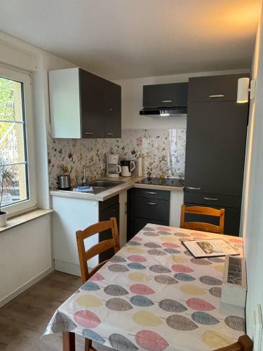 a kitchen with a table and chairs and a kitchen with black cabinets at Seeblick Apartments Mühlau in Mühlau