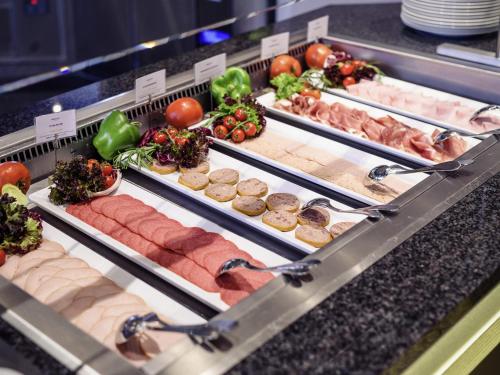 a display case with many different types of food at Mercure Düsseldorf Kaarst in Kaarst