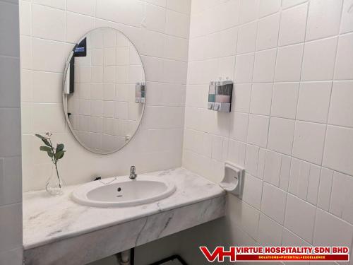 a bathroom with a sink and a mirror at Aurora Court Service Apartment in George Town