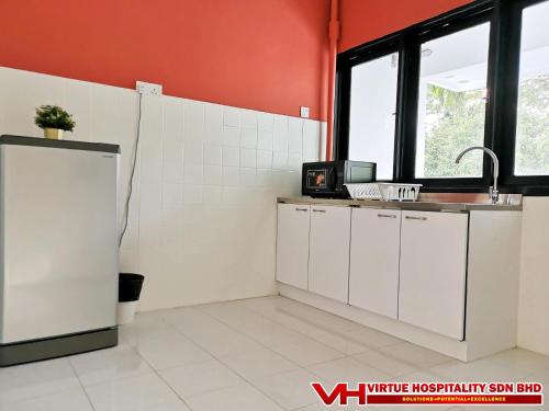 a kitchen with white cabinets and a refrigerator at Aurora Court Service Apartment in George Town