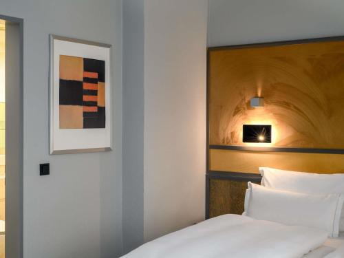 a bedroom with a bed and a picture on the wall at Mercure Hotel Dortmund Centrum in Dortmund