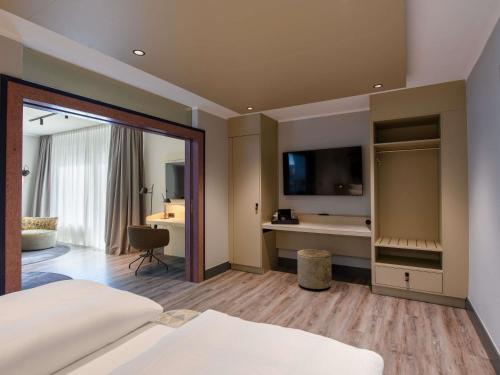a hotel room with a bed and a desk at Mercure Hotel Dortmund Centrum in Dortmund