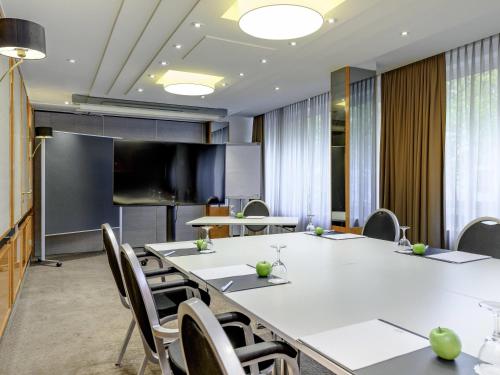 a conference room with a large table and chairs at Mercure Hotel Dortmund Centrum in Dortmund