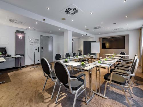 a conference room with a long table and chairs at Mercure Hotel Dortmund Centrum in Dortmund
