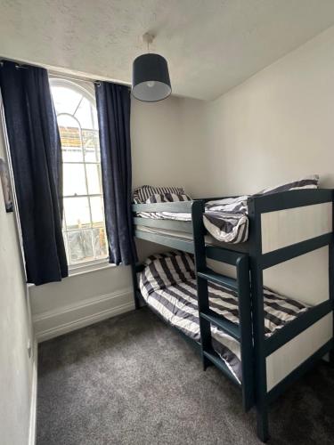 a dorm room with two bunk beds and a window at Seaside stay in Teignmouth in Teignmouth