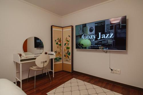 a room with a bed and a desk and a mirror at Stay Vibe Healing House in Seoul