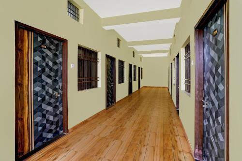 an empty hallway in a school with wood floors and doors at Hotel O 0771 in Raipur