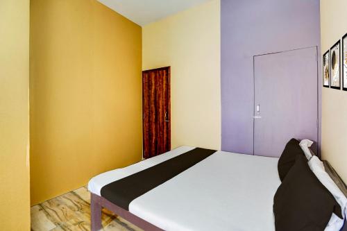 a bedroom with a bed with yellow and purple walls at Hotel O Euphoria inn in Morādābād