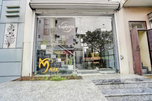 a store window with a sign that says pay at Hotel O Euphoria inn in Morādābād