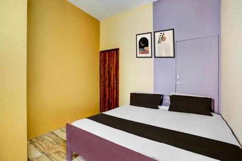 a bedroom with a bed with yellow and purple walls at Hotel O Euphoria inn in Morādābād