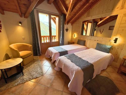 a bedroom with two beds and a chair in a room at Chalet 5 pièces, 8 pers, au coeur de St Martin de Belleville, proche pistes et commodités - FR-1-452-65 in Saint-Martin-de-Belleville
