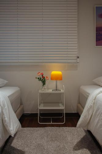 a room with two beds and a table with a lamp at Stay Vibe Healing House in Seoul