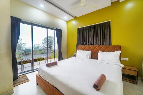 a bedroom with a large bed and a large window at Sukoon Ghar By Natures Sweet Homes in Mahabaleshwar
