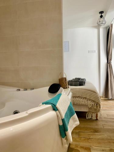 a bathroom with a bath tub and a bed at Le Nid Marin in Ault