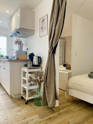 a room with a kitchen and a bed and a table at Le Nid Marin in Ault