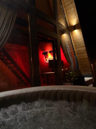 a hot tub in a room with a fire in the window at Nomad House Arilje in Arilje