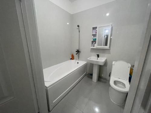 Un baño con bañera, inodoro y lavabo. en Sunrise Guesthouse UB, en Ulán Bator