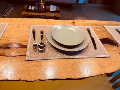 a table with a plate and spoon and fork and knife at Al Tanoor House in Nizwa
