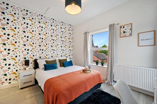 a bedroom with a bed and a large window at Edegely House in Stockport