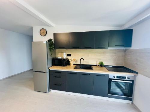a kitchen with blue cabinets and a refrigerator at Antonia home in Târgu-Mureş