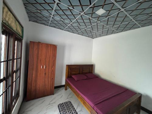 a bedroom with a bed in a room with a window at Villa Mulberry in Anuradhapura