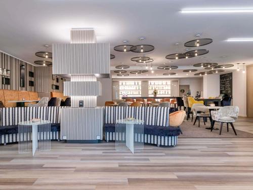 a restaurant with blue and white chairs and tables at Mercure Hannover Oldenburger Allee in Hannover