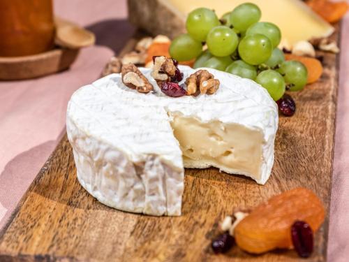 ein Stück Käse mit Trauben und Nüssen auf einem Schneidebrett in der Unterkunft Mercure Hannover Oldenburger Allee in Hannover