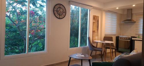 a kitchen with a table and a clock on the wall at Flamboyant Residence 46 in Koolbaai