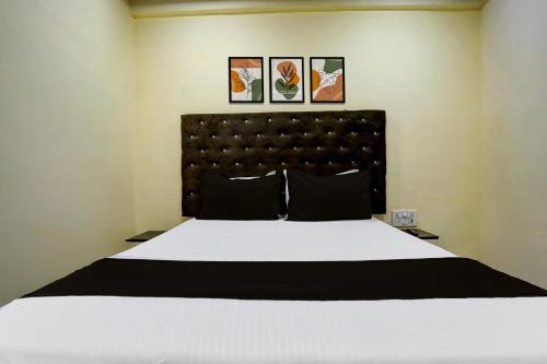 a bedroom with a large white bed with three pictures on the wall at Hotel O Royal Inn in Mumbai