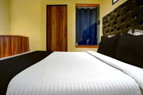 a large white bed in a room with a window at Hotel O Royal Inn in Mumbai
