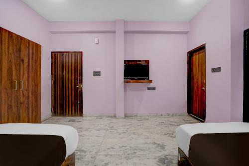 a room with two beds and a tv on the wall at Hotel O G9 in Akolia