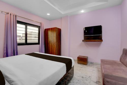 a bedroom with a bed and a tv and a couch at Hotel O G9 in Akolia