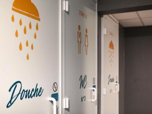 a locker room with orange and blue writing on the wall at hotelF1 Beauvais in Beauvais