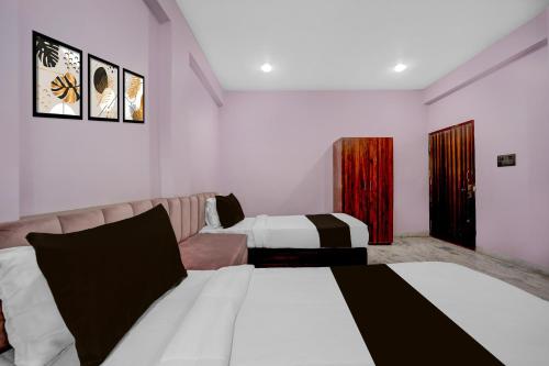 a hotel room with two beds and a couch at Hotel O G9 in Akolia
