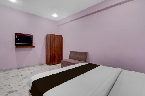 a bedroom with a bed and a chair and a television at Hotel O G9 in Akolia