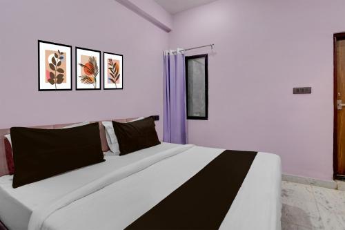 a bedroom with a large bed with black and white pillows at Hotel O G9 in Akolia